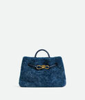 Top handle bag in merino shearling with denim effect. Featuring signature knot detail and sliding cross-body strap.