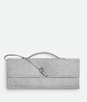 Top handle clutch in supple leather with all-over crystal detailing and signature knot closure.